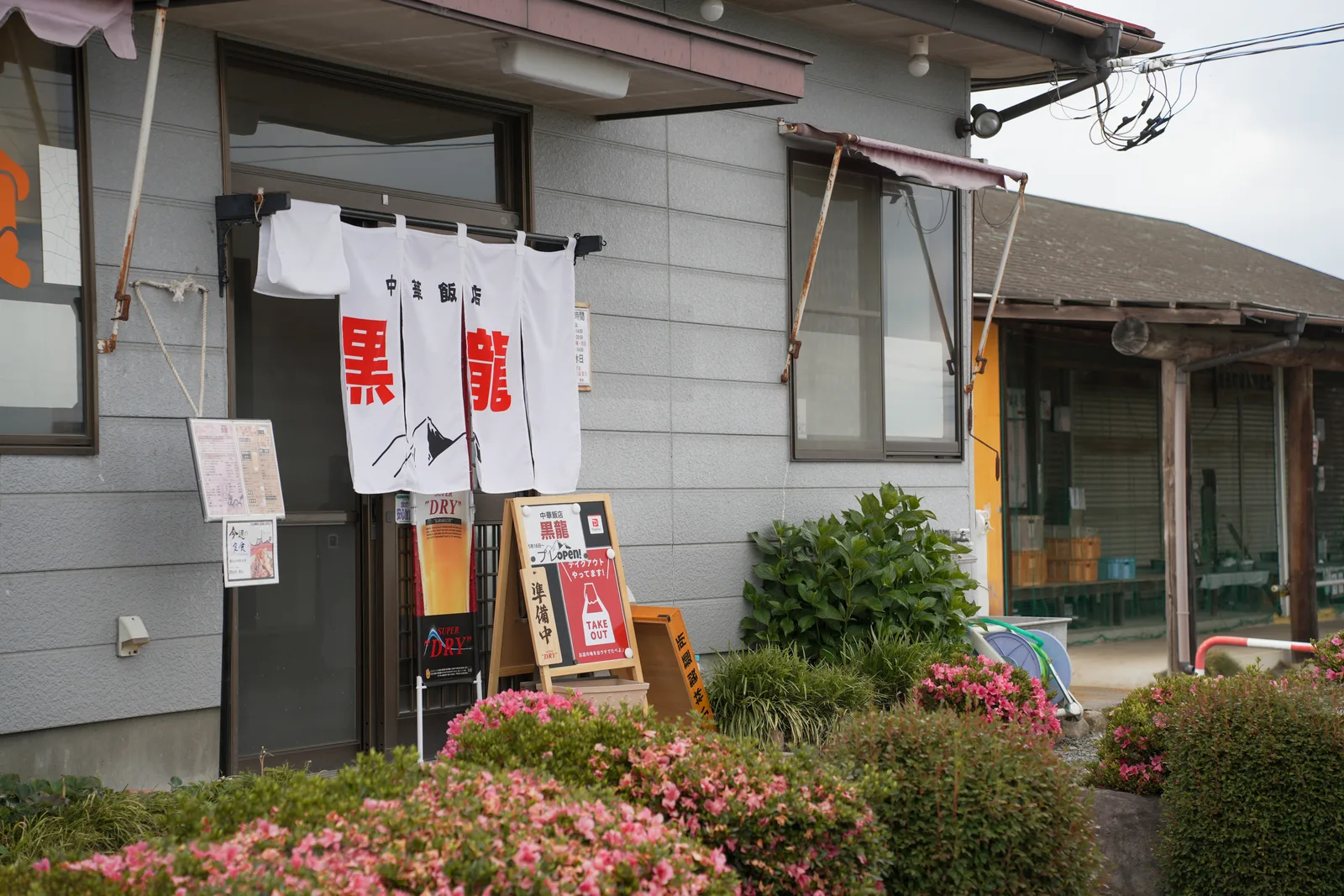 黒龍の外観。暖簾とつつじ