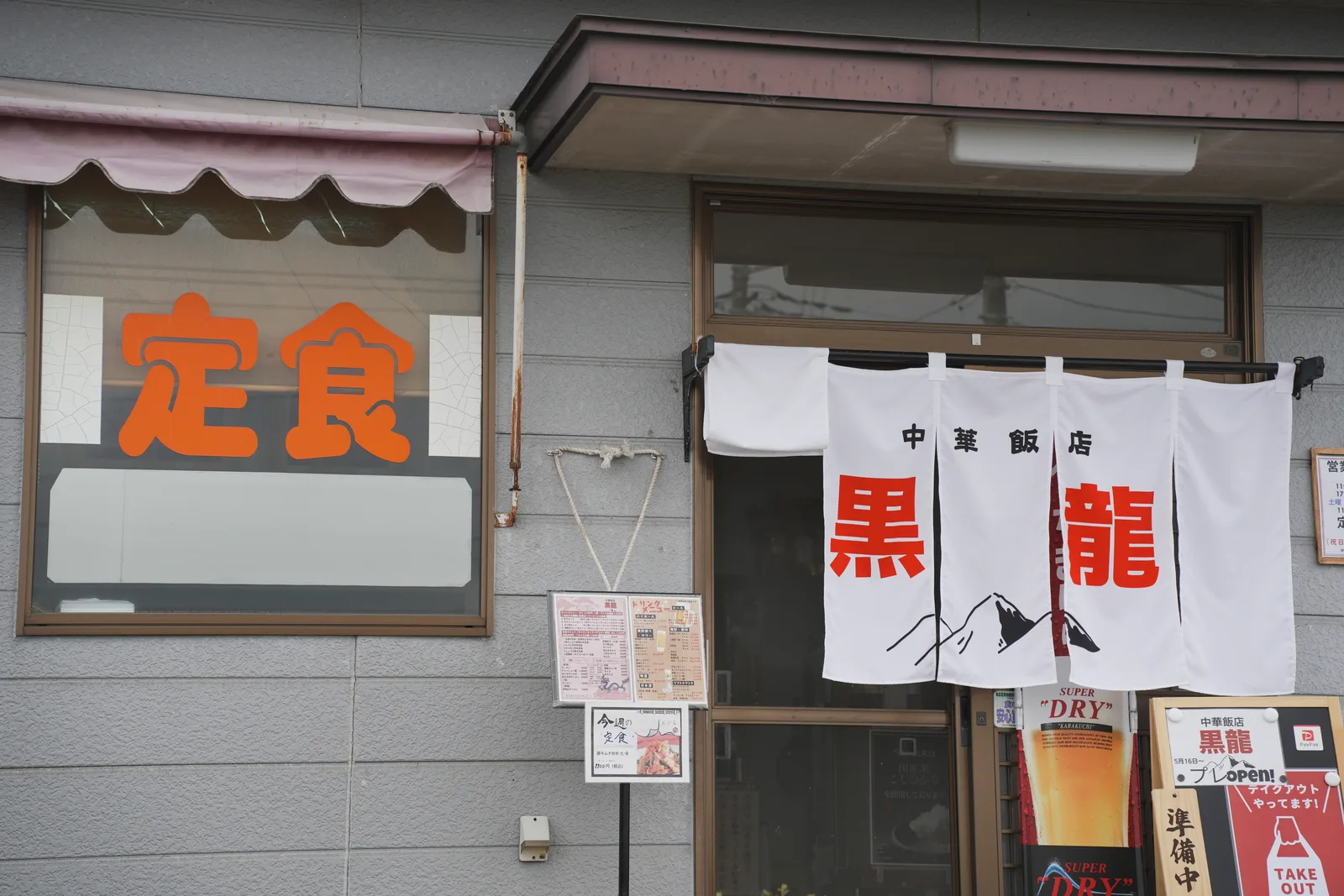 黒龍の店先。「定食」の窓と暖簾